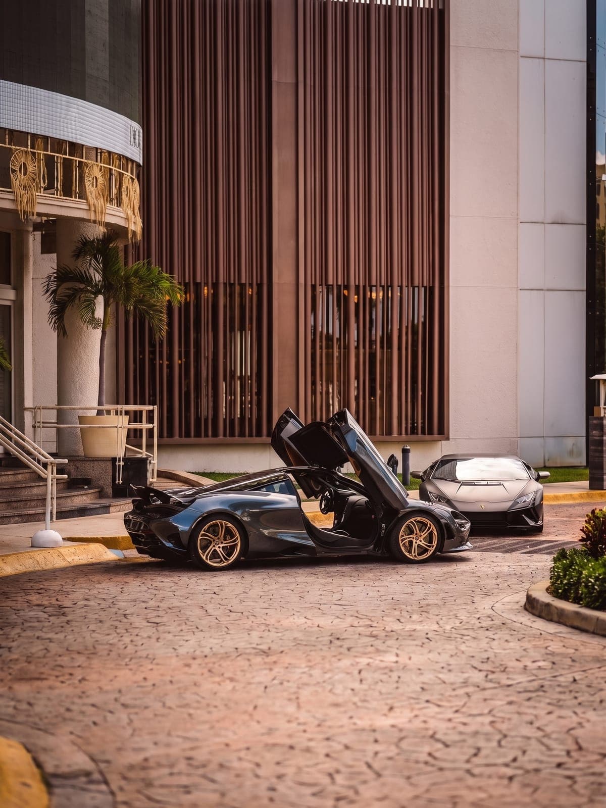 McLaren 750S con las puertas de mariposa abiertas frente a un edificio.