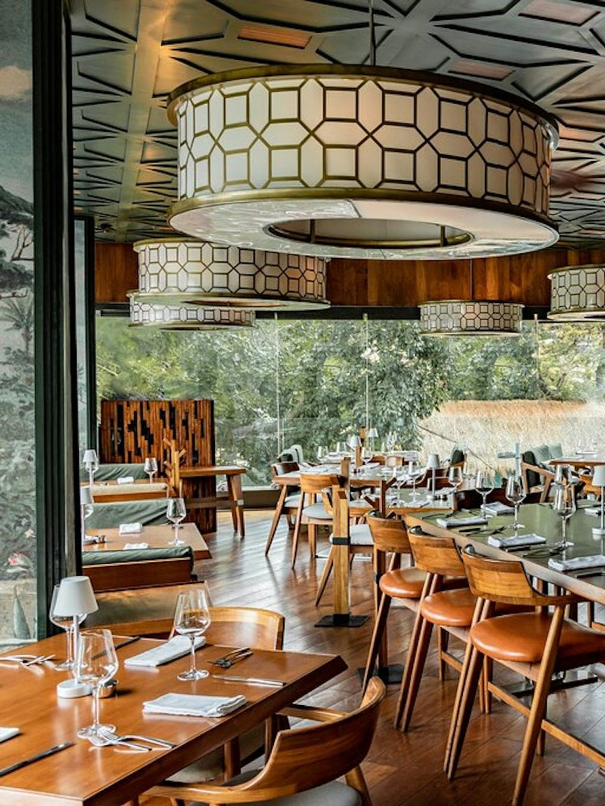 Harry's, steakhouse en Playa del Carmen: salón con lámparas caladas y ventanales abiertos a la vegetación.