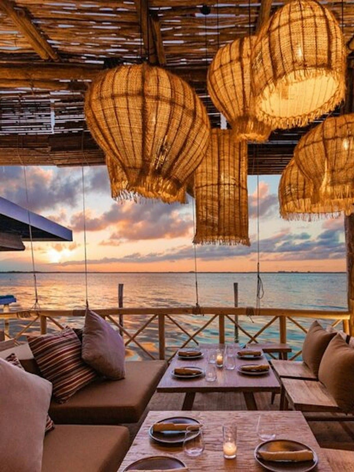 Funky Geisha, cocina asiática en Cancún: lounge frente al mar al atardecer con lámparas de ratán.