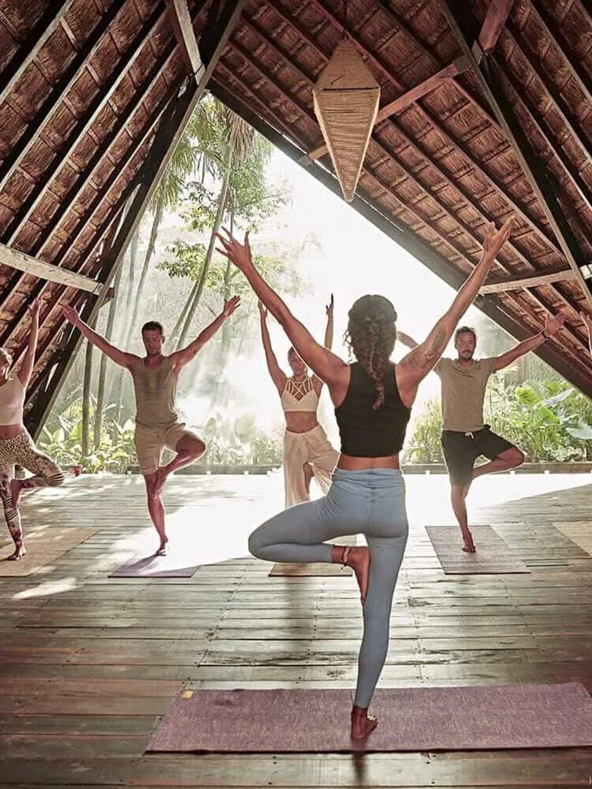 Sesión de yoga en una palapa abierta al amanecer.