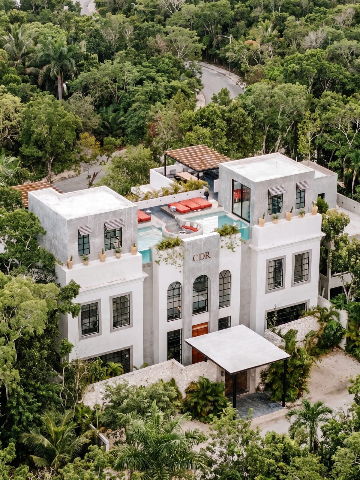 Casa Don Rey, a private residence in Tulum, Riviera Maya: a white three-story facade with a rooftop pool and loungers.