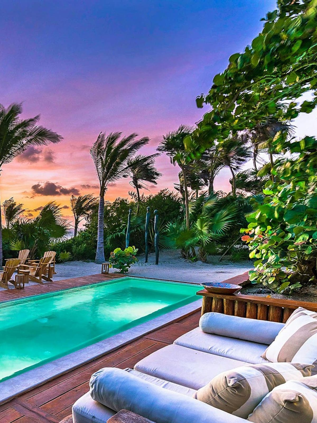 Casa Cantarena, an oceanfront villa in Sian Ka'an, Riviera Maya: a pool and loungers under a mauve sky at sunset.