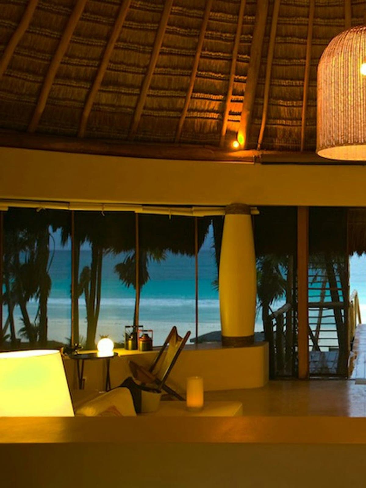 Casa Nalum, an oceanfront villa in Sian Ka'an, Riviera Maya: a palapa lit at night, open to the sea.