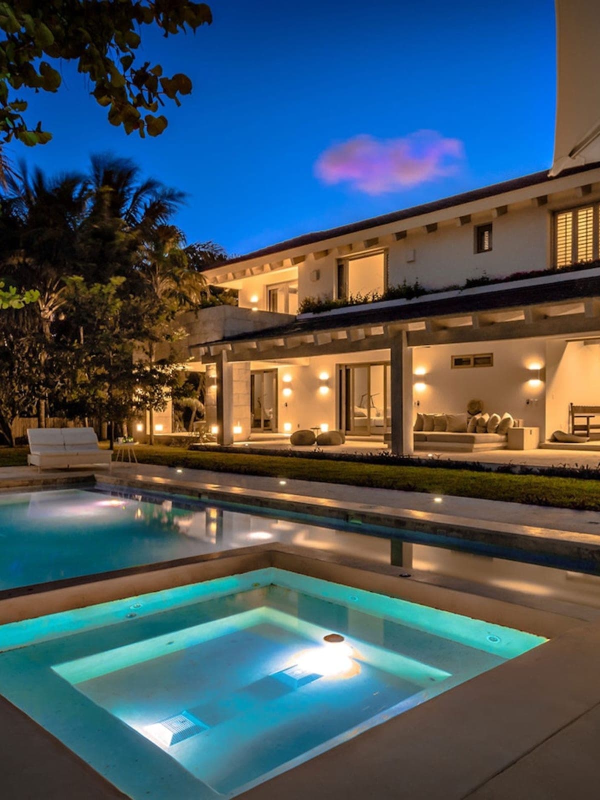 Casa Ixchel, a design home in Tulum, Riviera Maya: a modern villa with a pool and jacuzzi lit at dusk.