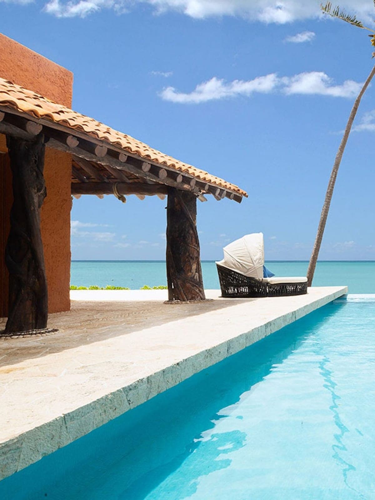 Casa Corazón, an oceanfront villa in Playa del Carmen, Riviera Maya: a palapa and pool facing turquoise water.