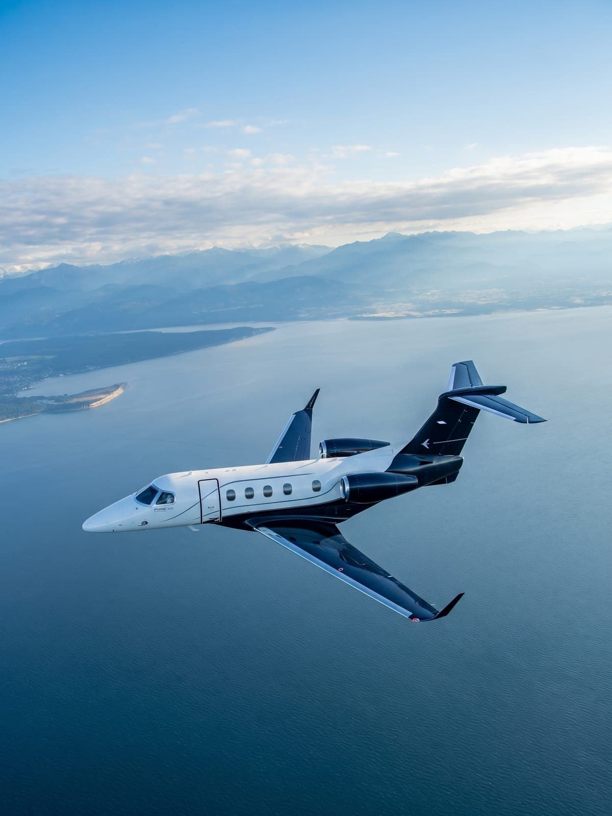 Jet Embraer Phenom 300 en vuelo sobre el mar.