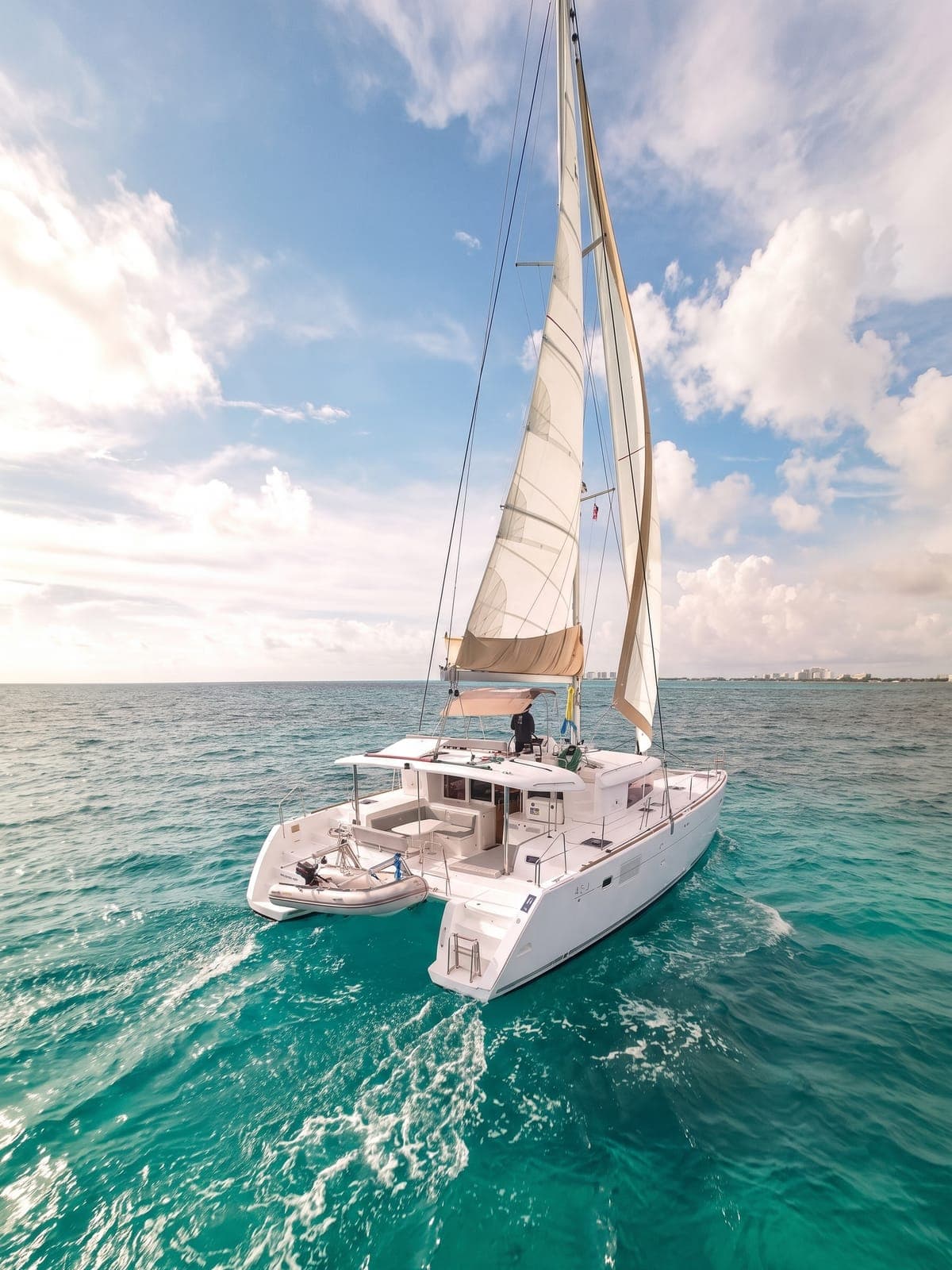 Catamarán a motor navegando sobre agua turquesa.
