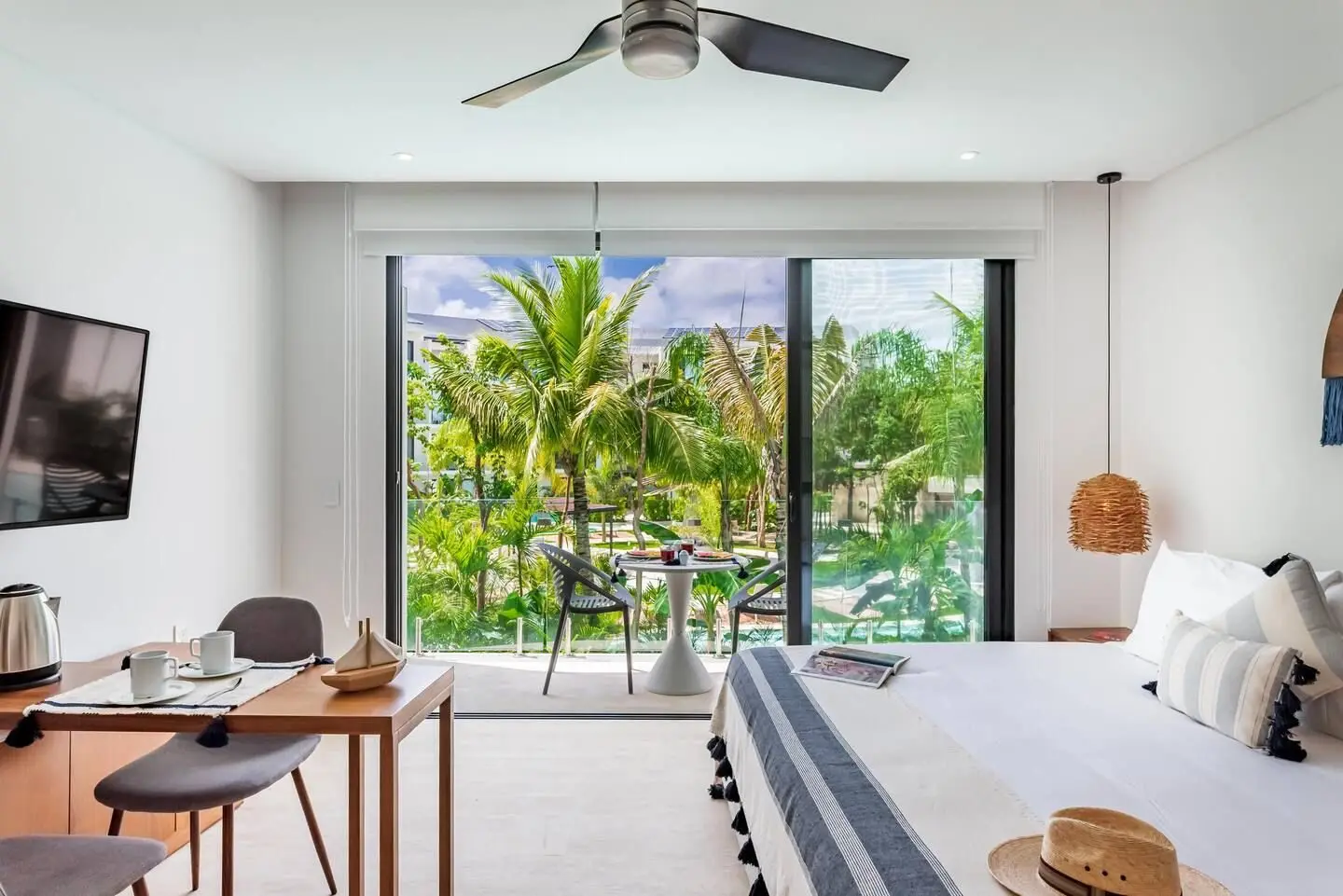 Estudio con cama king y ventanal hacia las albercas en Central Park Lagunas